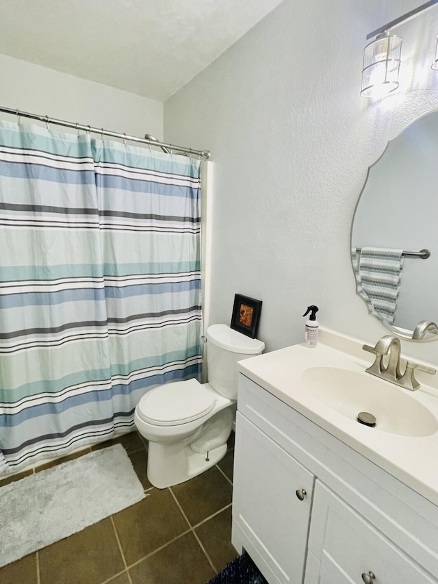 bathroom with toilet, vanity, tile patterned flooring, and walk in shower