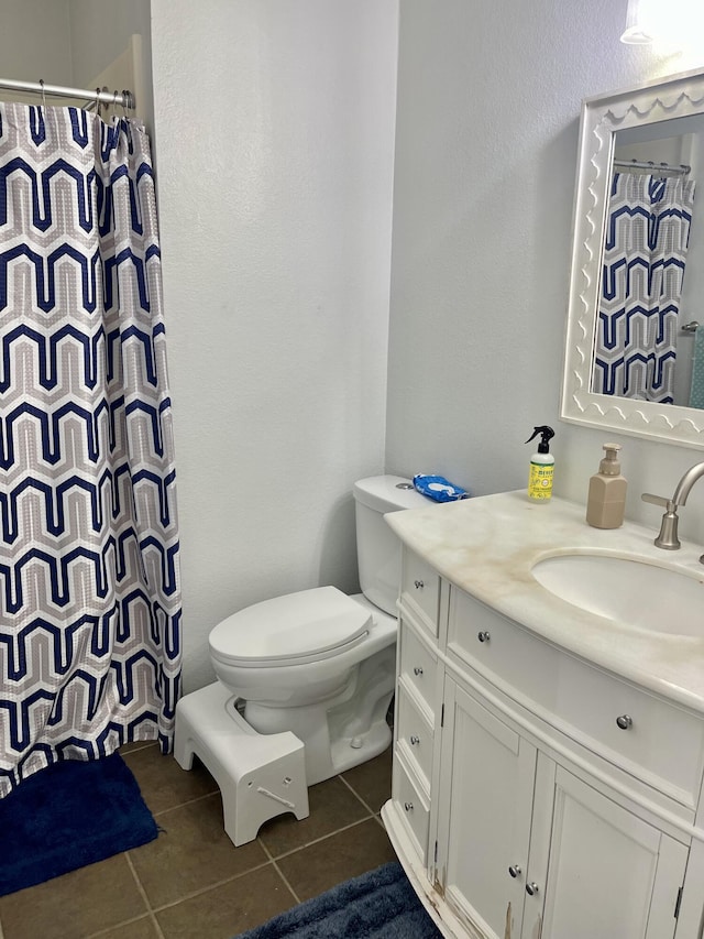 bathroom featuring toilet, vanity, a shower with shower curtain, and tile patterned flooring