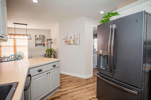 kitchen with pendant lighting, white cabinetry, stainless steel fridge with ice dispenser, and light wood-type flooring