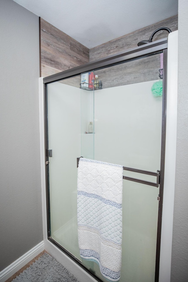 bathroom featuring a shower with door