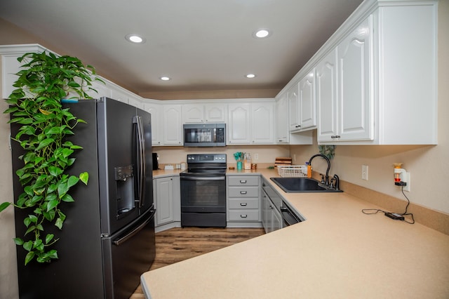 kitchen featuring sink, wood-type flooring, white cabinets, and stainless steel appliances