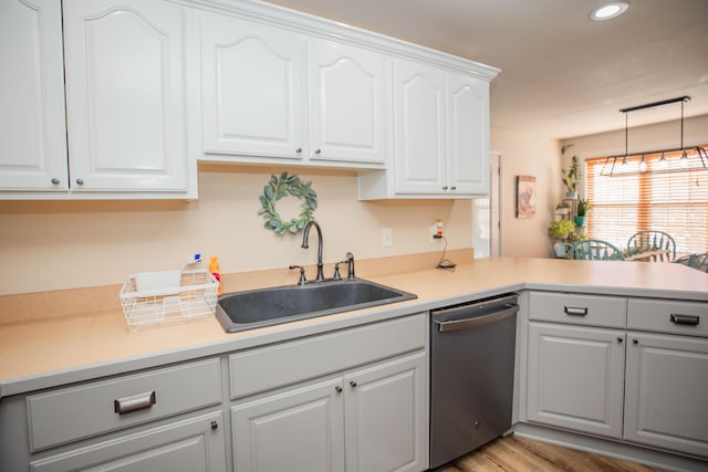 kitchen with dishwasher, decorative light fixtures, white cabinetry, light hardwood / wood-style floors, and sink