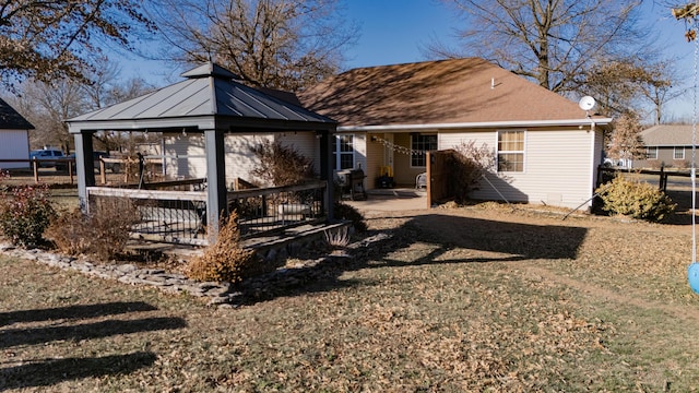 back of house featuring a gazebo and a lawn