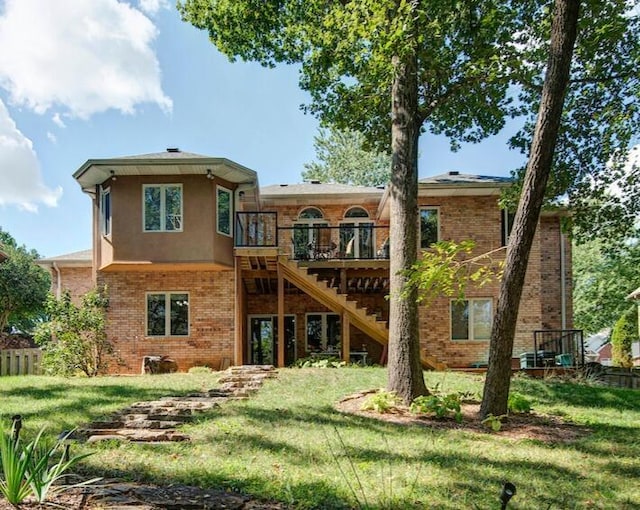 back of property featuring a wooden deck and a lawn