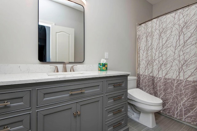 bathroom featuring curtained shower, toilet, and vanity