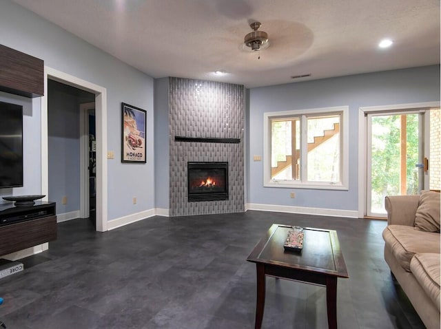 living room with ceiling fan and a fireplace