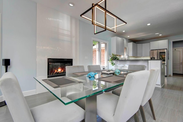 dining room featuring a large fireplace and sink