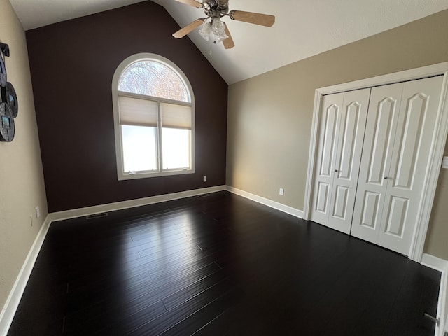 unfurnished bedroom with ceiling fan, dark hardwood / wood-style flooring, a closet, and lofted ceiling