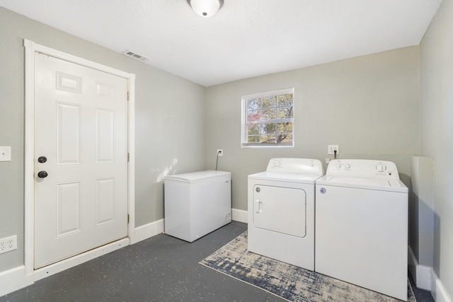 clothes washing area featuring laundry area, separate washer and dryer, visible vents, and baseboards