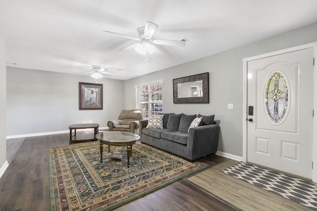 living room with a ceiling fan, dark wood finished floors, and baseboards