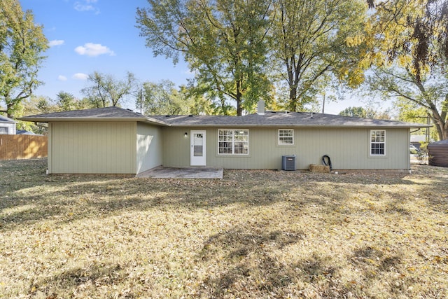 back of house with central AC unit and fence