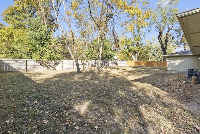 view of yard with a fenced backyard and central AC unit