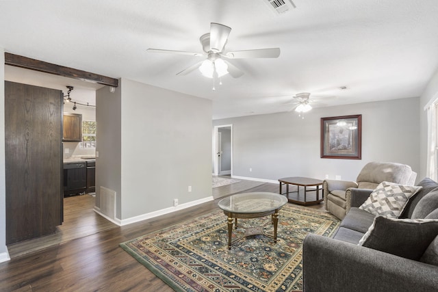 living area with baseboards, visible vents, dark wood finished floors, and a ceiling fan