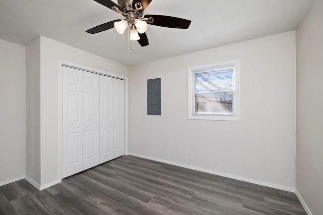 unfurnished bedroom featuring ceiling fan, electric panel, a closet, and dark hardwood / wood-style flooring