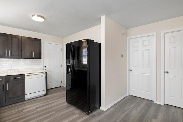 kitchen featuring hardwood / wood-style floors, dishwasher, backsplash, black fridge, and dark brown cabinets