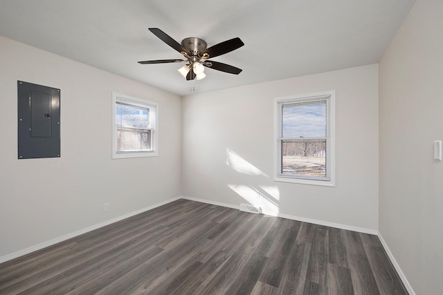 spare room featuring ceiling fan, electric panel, and dark hardwood / wood-style flooring