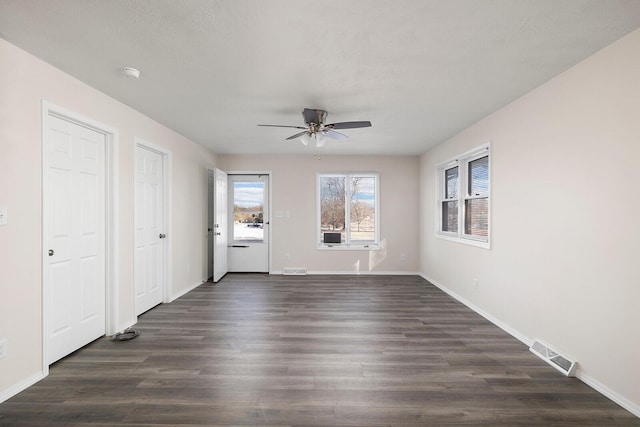 unfurnished room with dark wood-type flooring and ceiling fan