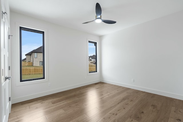 empty room with ceiling fan and light hardwood / wood-style floors