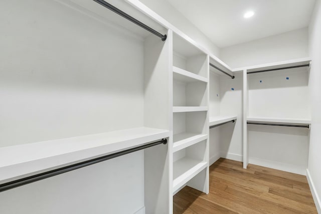 walk in closet with light hardwood / wood-style flooring