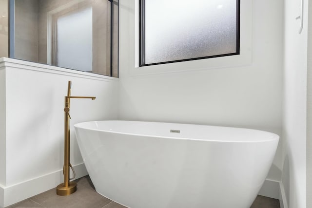 bathroom with a bath, tile patterned floors, and plenty of natural light