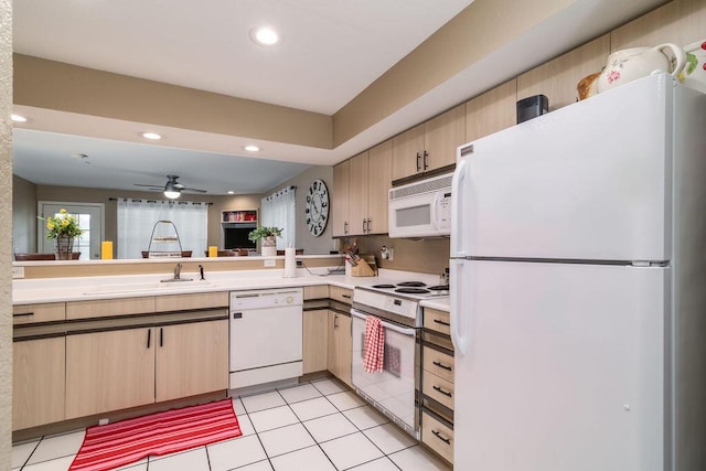 kitchen featuring light tile patterned flooring, light brown cabinetry, white appliances, and kitchen peninsula