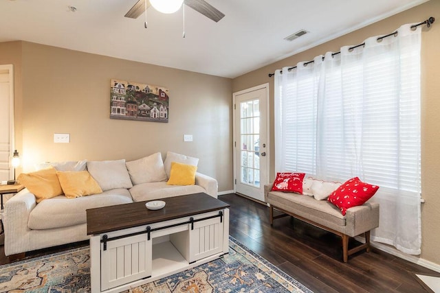 living room featuring ceiling fan and dark hardwood / wood-style flooring