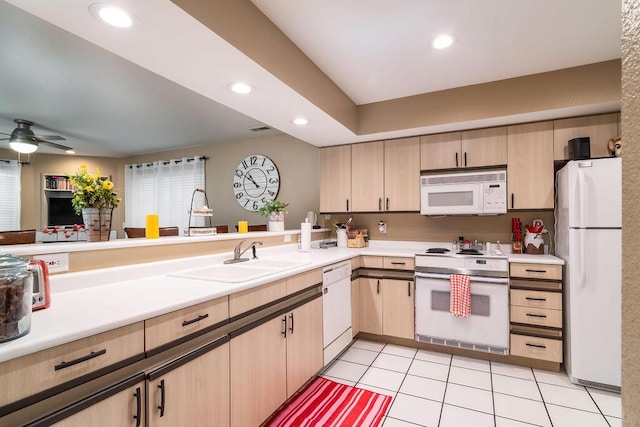 kitchen featuring sink, white appliances, light tile patterned floors, light brown cabinetry, and kitchen peninsula