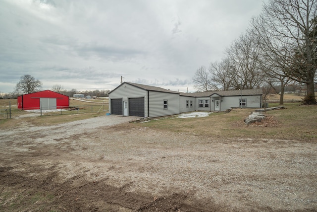 rear view of house featuring a garage, an outbuilding, and a lawn