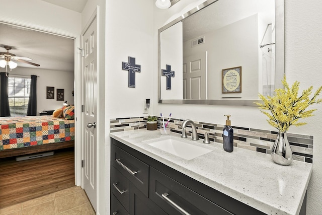 bathroom featuring ceiling fan, tile patterned flooring, backsplash, and vanity