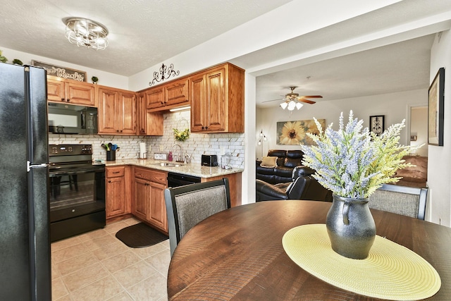 kitchen featuring ceiling fan, black appliances, decorative backsplash, light tile patterned flooring, and sink