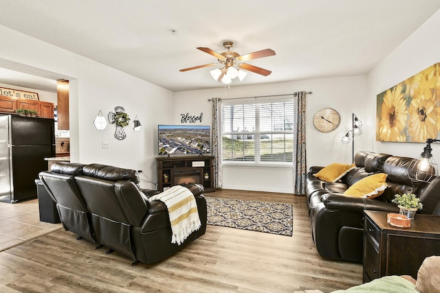 living room featuring ceiling fan and light wood-type flooring