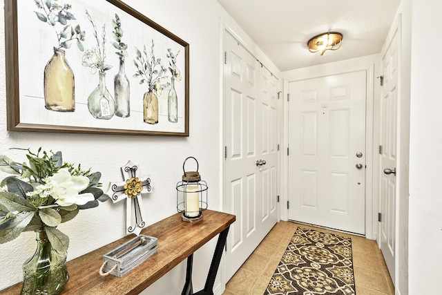 doorway with light tile patterned flooring