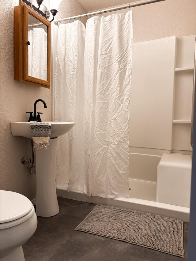 bathroom featuring shower / tub combo with curtain and toilet