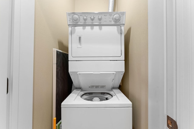 washroom with stacked washing maching and dryer