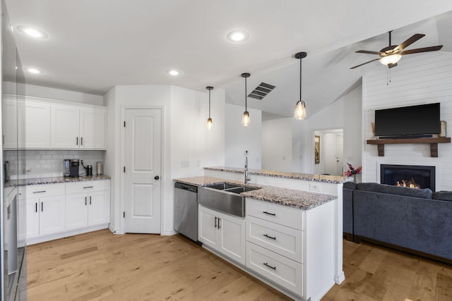 kitchen with white cabinets, dishwasher, a fireplace, tasteful backsplash, and hanging light fixtures