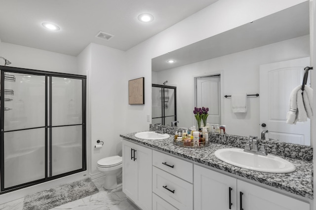 bathroom featuring an enclosed shower, vanity, and toilet