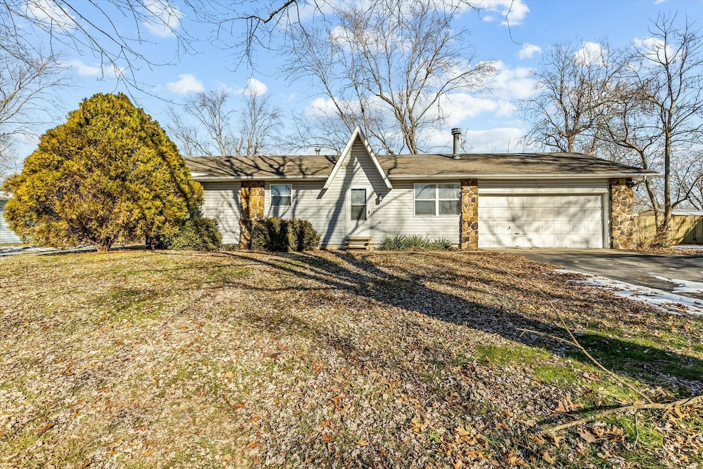 single story home with a front yard and a garage