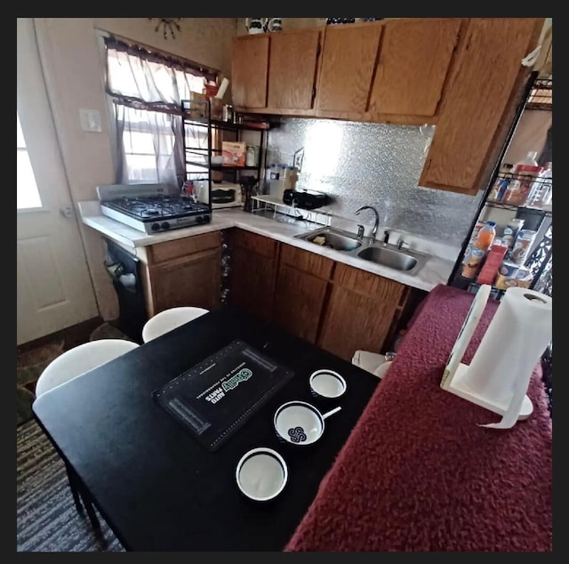 389 Osage Ln, Pineville, MO 64856 - kitchen with a sink, backsplash, brown cabinets, and light countertops