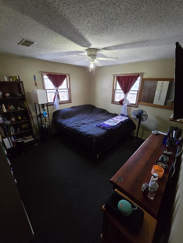 bedroom with ceiling fan and a textured ceiling