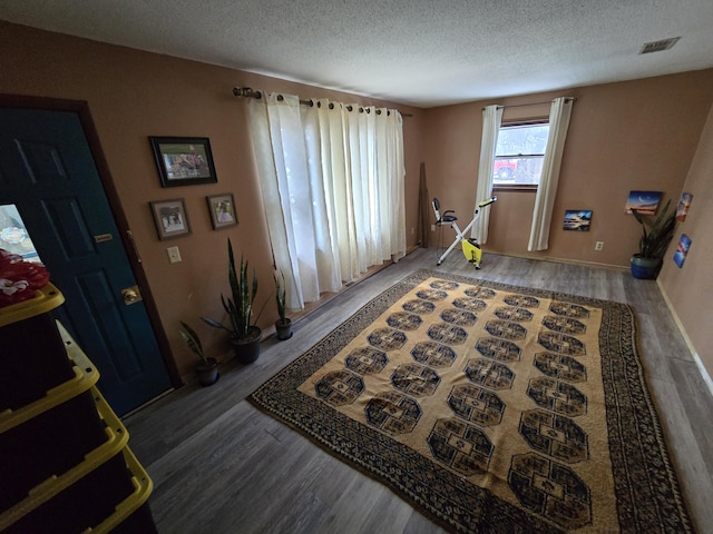 interior space featuring a textured ceiling and hardwood / wood-style floors