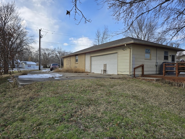 exterior space with a garage and a lawn