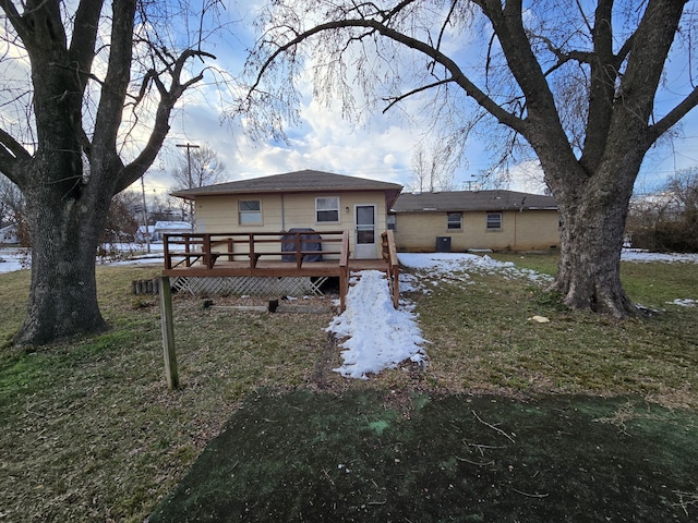 snow covered property with a yard and a wooden deck