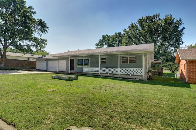 view of front of property featuring a front lawn, covered porch, and a garage