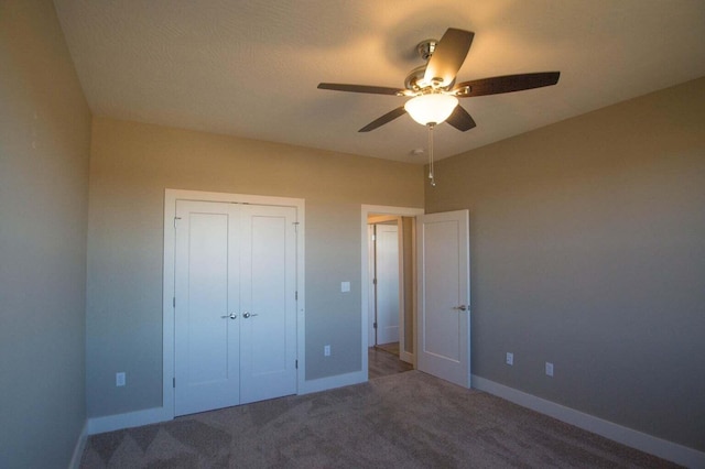 unfurnished bedroom with ceiling fan, a closet, and carpet floors