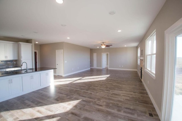 kitchen with hardwood / wood-style flooring, ceiling fan, decorative backsplash, white cabinets, and sink