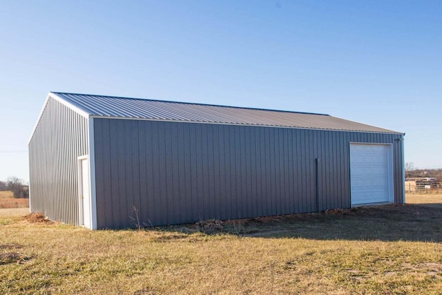 view of outdoor structure with a garage and a lawn