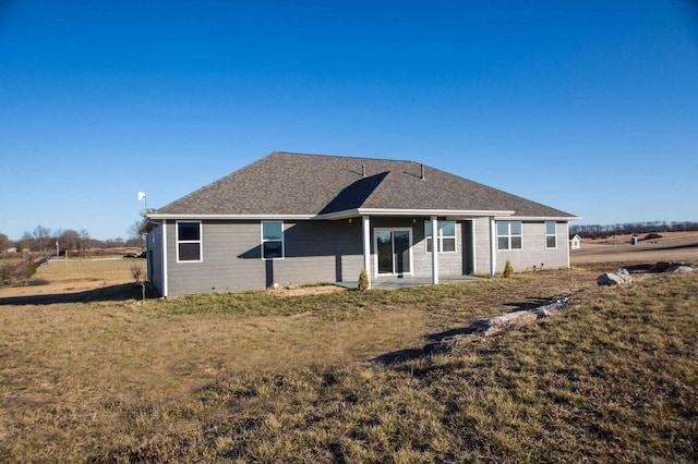 rear view of property with a lawn