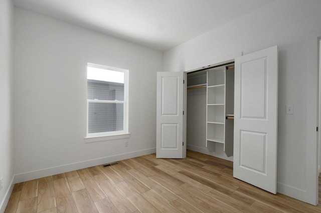 unfurnished bedroom featuring a closet and light hardwood / wood-style flooring