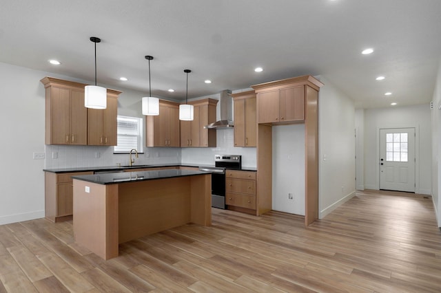 kitchen featuring a center island, electric stove, hanging light fixtures, wall chimney exhaust hood, and sink