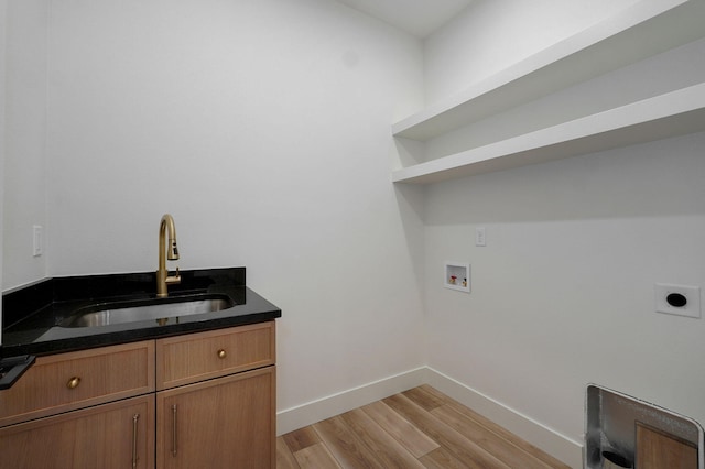 clothes washing area with electric dryer hookup, light wood-type flooring, hookup for a washing machine, cabinets, and sink